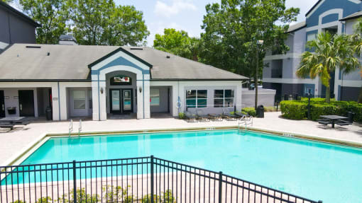 Swimming pool with lounge seating and clubhouse in the background