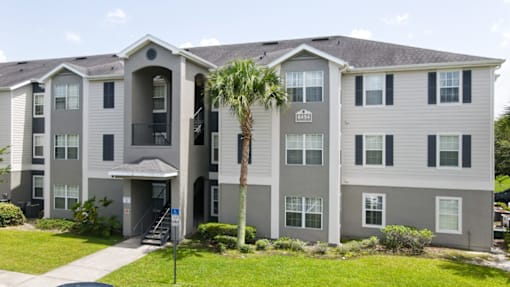 A large apartment complex with a palm tree in front.