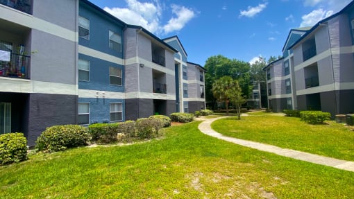 Apartment building exterior surrounded by native landscaping and exterior walkways