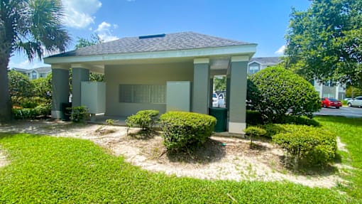 A house with a green lawn and trees in the background.