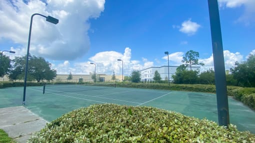 Outdoor tennis court with apartment building exterior in the background