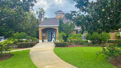Club House Entrance with long sidewalk surrounded by trees