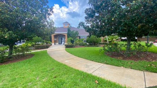 Club House Entrance with long sidewalk surrounded by trees