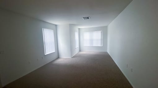 Carpeted Living Room with three windows