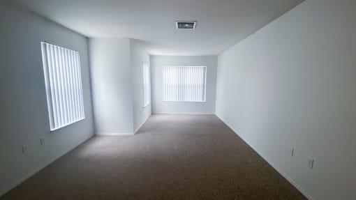 Carpeted Living Room with three windows