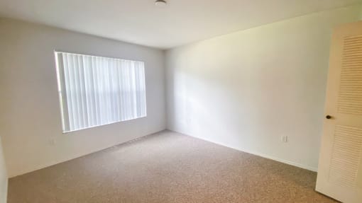 Carpeted Bedroom with white walls and one widow