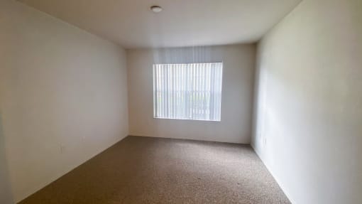 Carpeted Bedroom with white walls and one widow