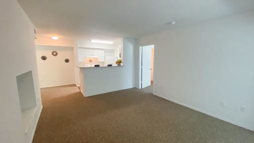 Carpeted Living Room with kitchen/dining room view,  fluorescent tube lighting in kitchen