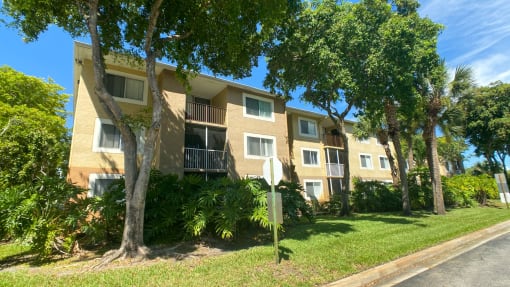 Apartment Building Exterior Surrounded by Bushes and Trees