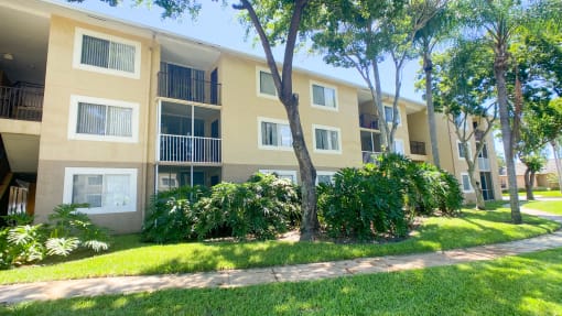 Apartment Building Exterior Surrounded by Bushes and Trees