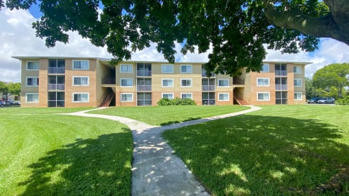 Apartment Building Exterior with Walkway Shaded by Trees