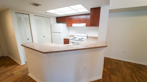 Breakfast Bar off Kitchen with White Appliances, Wood Cabinets and Tan Counters