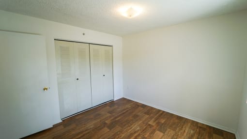 Bedroom with Hardwood Style Flooring and Closet with Sliding Doors