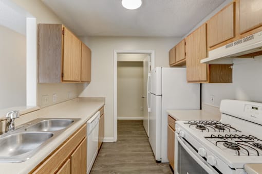 the preserve at ballantyne commons apartment kitchen with white appliances and wood cabinets