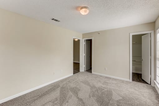 an empty living room with white walls and a carpeted floor