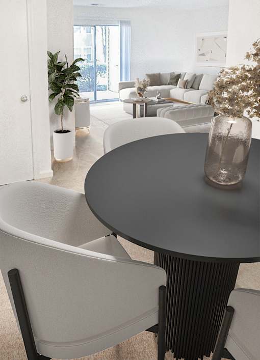 A modern living room with a grey table and white chairs.