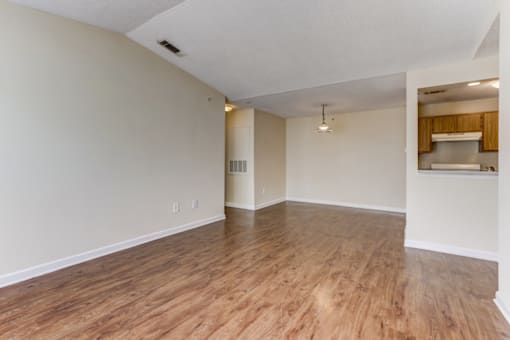 an empty living room with wood flooring and white walls