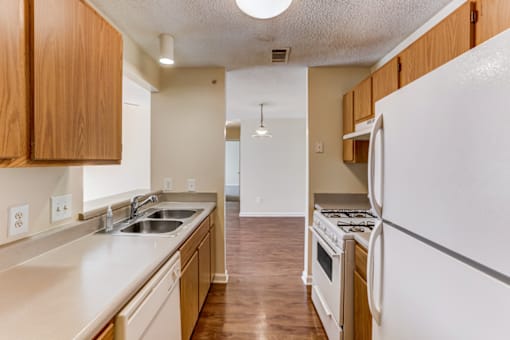 the preserve at ballantyne commons apartment kitchen with white appliances and wooden cabinets