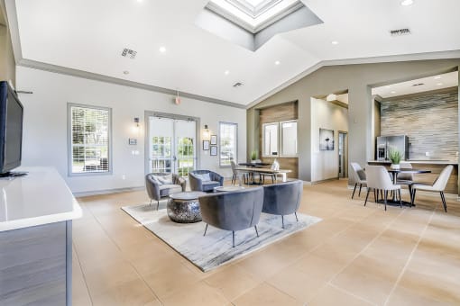 Clubhouse with conversational seating, dining areas, and a kitchen area with a stainless steel french door refrigerator.