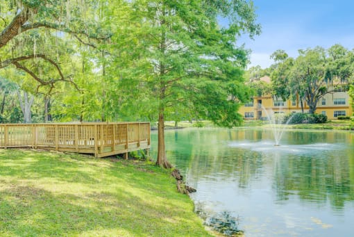 Side view of wooden deck overlooking lake with fountain and native landscaping