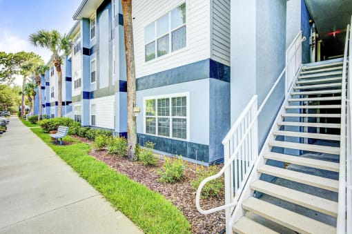 Apartment Building Exterior and Stairway Next to Grass and Decorative Plants