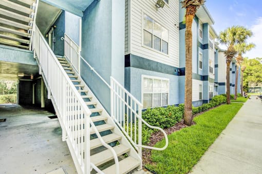 Apartment Building Exterior and Stairway Next to Grass and Decorative Plants
