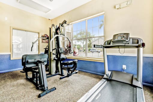 a home gym with exercise equipment and a large window