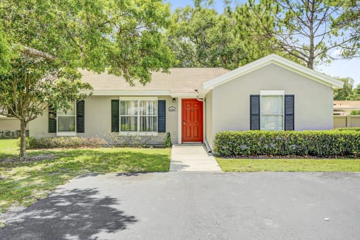 a white house with a red door and black shutters