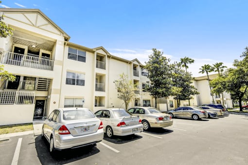Building exterior with parking lot view and cars.