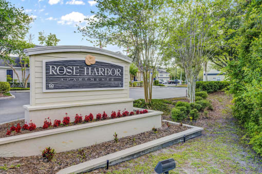 a sign at the entrance of rose harbor apartments
