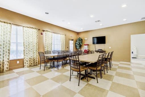 Club Room with Long Tables with Chairs, Mounted TV and Popcorn Machine Next to Windows