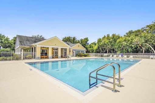Swimming Pool with Lounge Seating on Sun Deck Surrounded By Trees