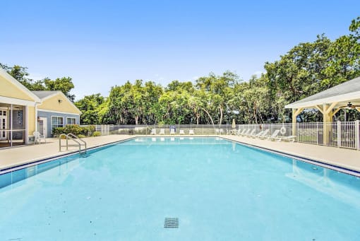 Swimming Pool with Lounge Seating on Sun Deck Surrounded By Trees