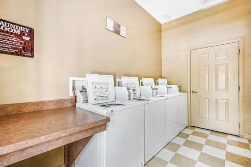 Laundry Facility with Wood Folding Table Next to Open Washing Machines