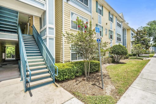 Apartment Building Exterior with Stairs Surrounded by Plants