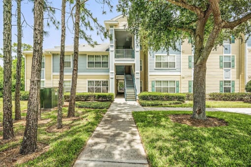 Apartment Building Exterior with Sidewalk Shaded by Trees