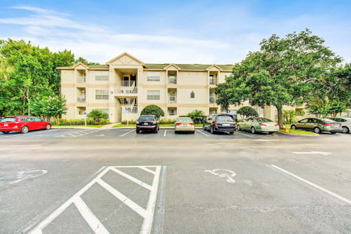 Building Exterior surrounded by shrubbery and trees with view of parking lot