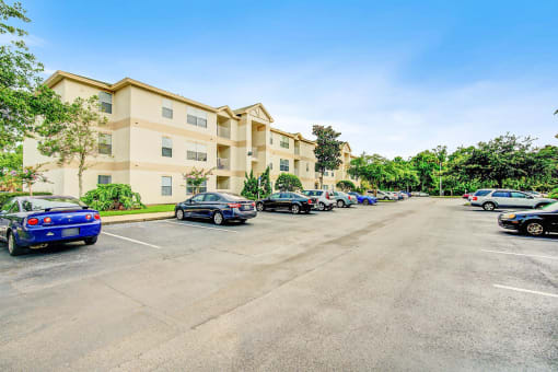 Building Exterior surrounded by shrubbery and trees with view of parking lot