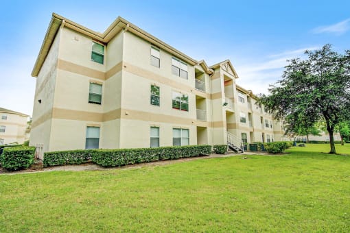 Building Exterior surrounded by shrubbery and trees with view of parking lot