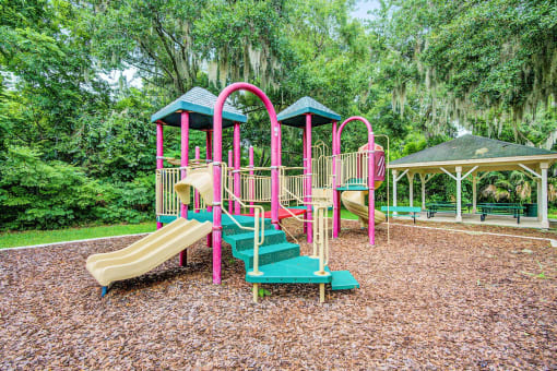Outdoor playground with two slides and several climbing areas.