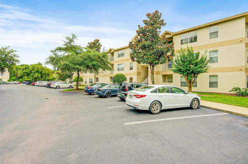 Building Exterior surrounded by shrubbery and trees with view of parking lot