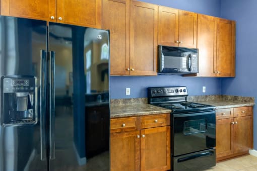 Clubhouse Kitchen with Wood Cabinet and Black Appliances