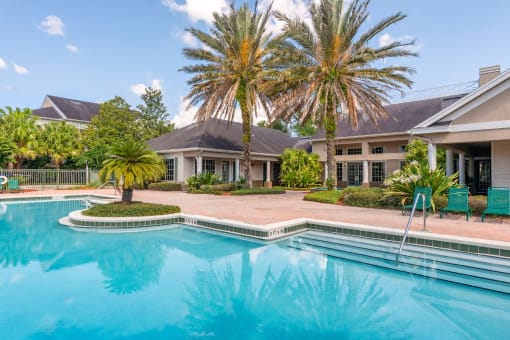 Leasing Office Exterior with Swimming Pool and Sun Deck with Lounge Chairs with Trees and Building Exteriors in the Background