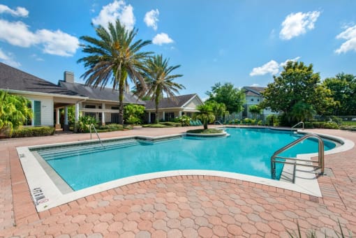 Leasing Office Exterior with Swimming Pool and Sun Deck with Lounge Chairs with Trees in the Background