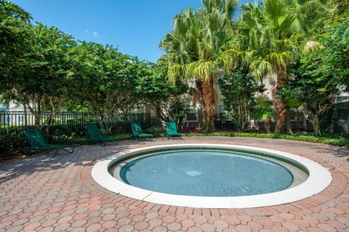 Fenced in Round Wading Pool with Lounge Chairs and Trees in the Background