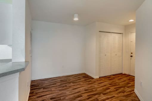 Breakfast Bar Next to Dining Room with Hardwood Style Flooring with Sliding Closet Next to Front Door