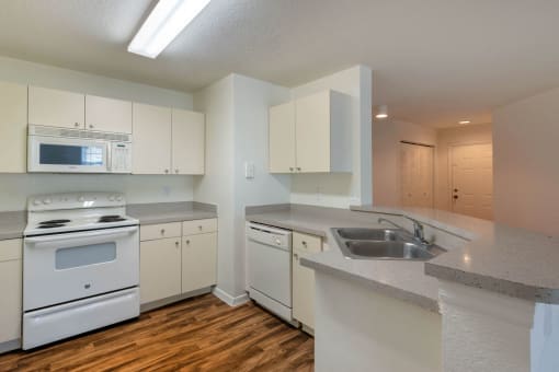 Fully Equipped Kitchen with White Appliances Including Dishwasher