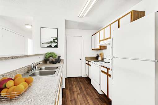 Galley kitchen with white appliances and wood cabinetry at Tierra Antigua Apartments, Mesa, AZ