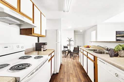 Galley kitchen with electric stove and dining view at Tierra Antigua Apartments, ARIZONA, 85207