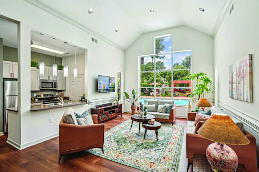 A living room with a couch, chairs, and a rug.